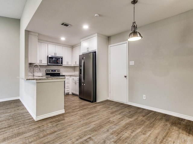 kitchen featuring white cabinets, tasteful backsplash, stainless steel appliances, and a sink