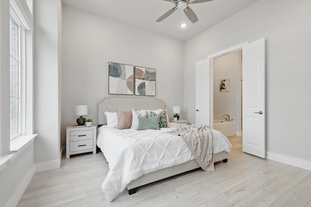 bedroom with light wood-style flooring, baseboards, ceiling fan, and ensuite bathroom