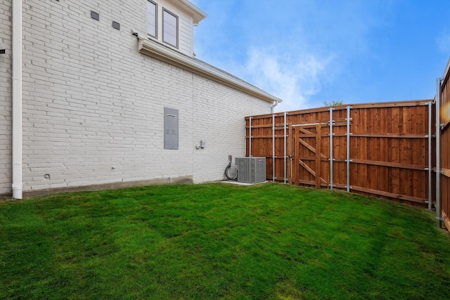 view of yard with a gate, fence, and cooling unit