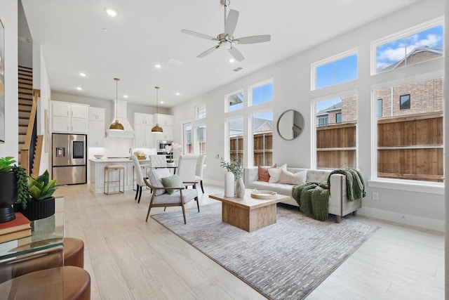 living area featuring light wood-type flooring, ceiling fan, baseboards, and recessed lighting