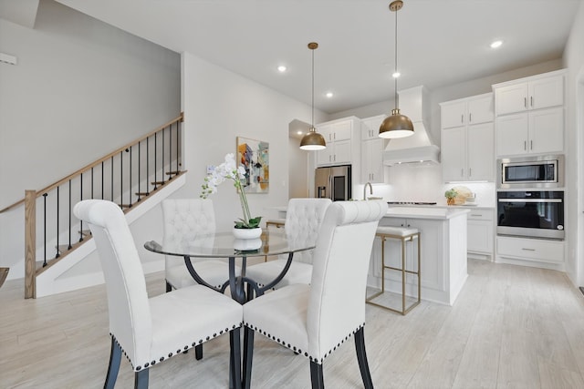 dining area featuring recessed lighting, stairway, and light wood finished floors