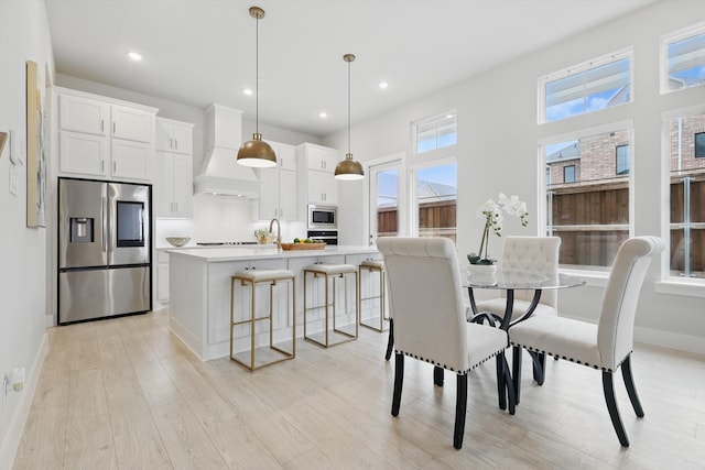 dining space with recessed lighting, baseboards, and light wood finished floors