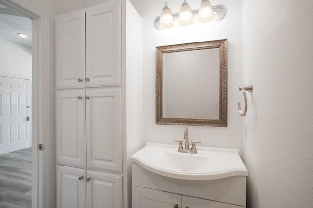 bathroom with wood finished floors and vanity