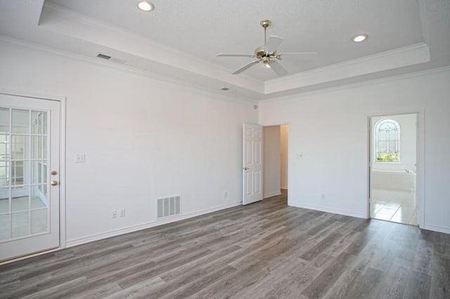 spare room featuring a raised ceiling and visible vents