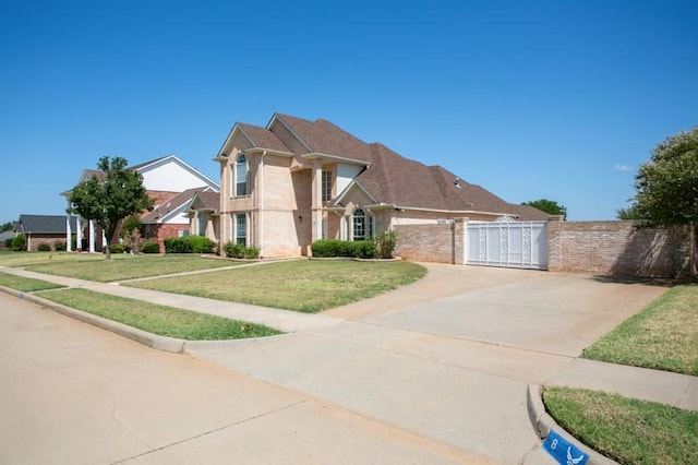 traditional home featuring brick siding, a front yard, fence, and a gate