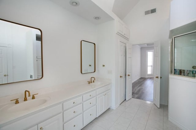 full bath with vaulted ceiling, visible vents, a sink, and an enclosed shower