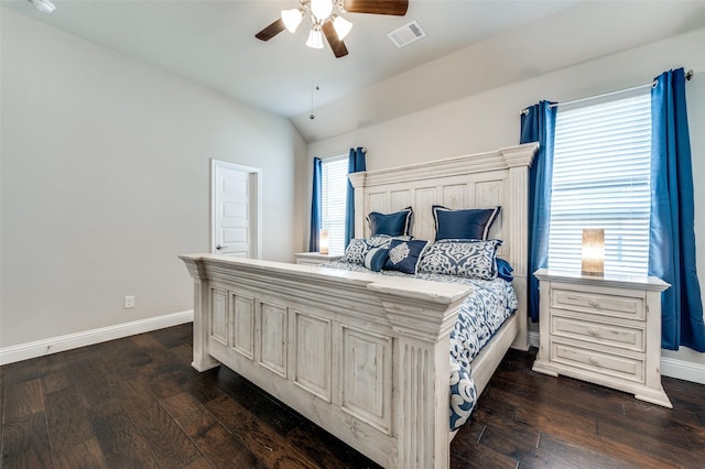 bedroom with dark wood-type flooring, visible vents, vaulted ceiling, and baseboards