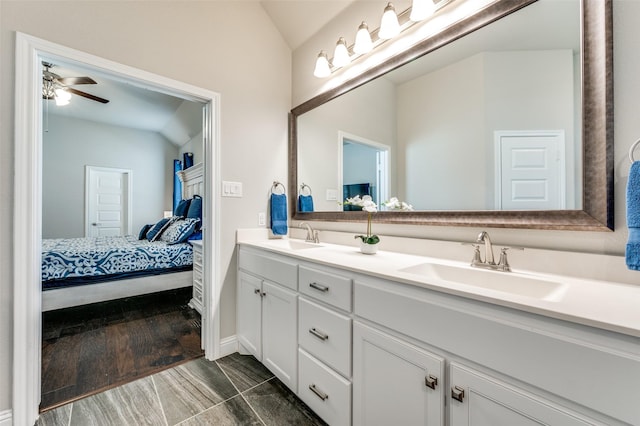 full bath with lofted ceiling, a sink, and connected bathroom