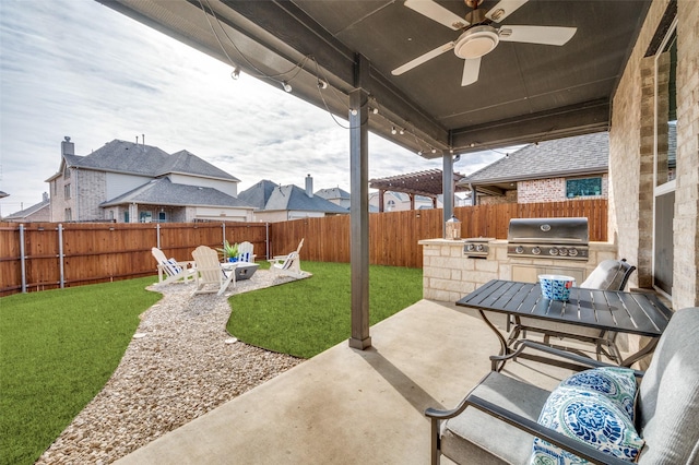 view of patio with a fire pit, area for grilling, a fenced backyard, and a ceiling fan