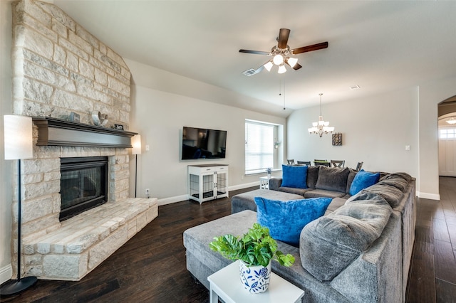 living room with wood-type flooring, ceiling fan with notable chandelier, baseboards, and a stone fireplace