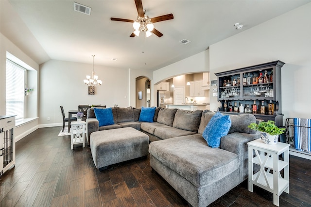 living room featuring vaulted ceiling, dark wood-type flooring, arched walkways, and visible vents