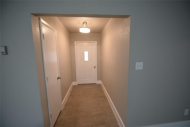 doorway featuring baseboards