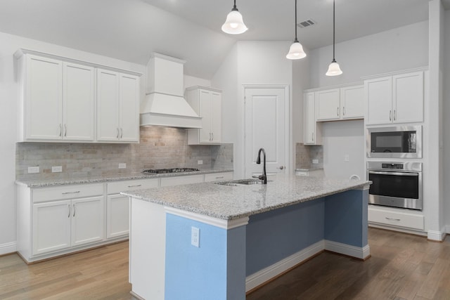 2121 Newton Ln, Mckinney, TX 75071 - kitchen with appliances with stainless steel finishes, a sink, white cabinets, custom range hood, and light wood-style flooring