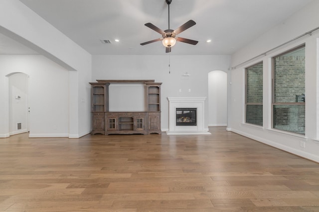 2121 Newton Ln, Mckinney, TX 75071 - unfurnished living room featuring light wood-style floors, arched walkways, a ceiling fan, recessed lighting, and visible vents