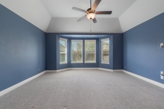 spare room with vaulted ceiling, ceiling fan, carpet flooring, and baseboards