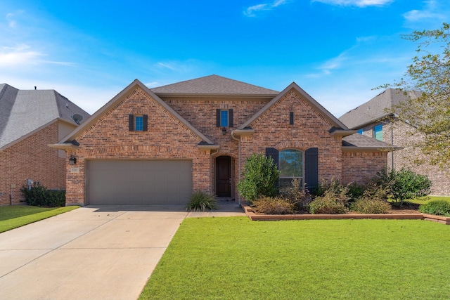 view of front of home with a garage, brick siding, driveway, roof with shingles, and a front yard