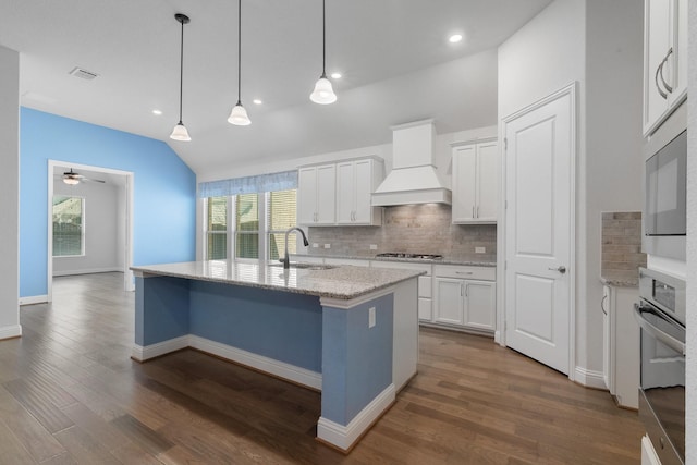 kitchen featuring white cabinetry, custom exhaust hood, stainless steel appliances, and a sink