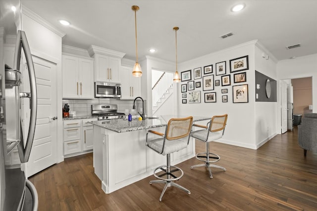 kitchen with stainless steel appliances, visible vents, a sink, and light stone counters