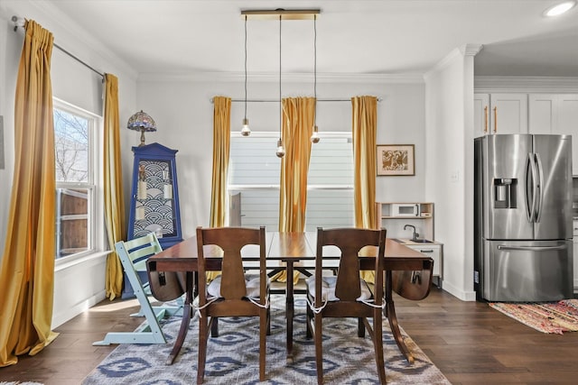 dining area featuring baseboards, dark wood finished floors, and crown molding