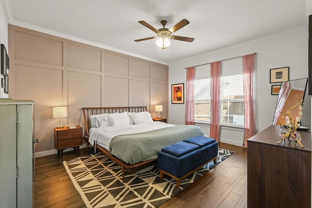 bedroom featuring a ceiling fan, ornamental molding, a decorative wall, and dark wood-style flooring