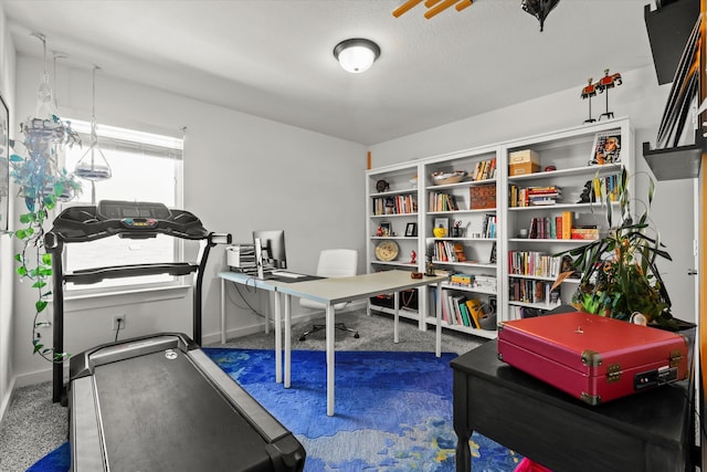 workout area featuring carpet and baseboards