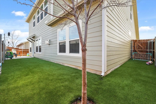 view of property exterior with a patio area, a fenced backyard, and a yard