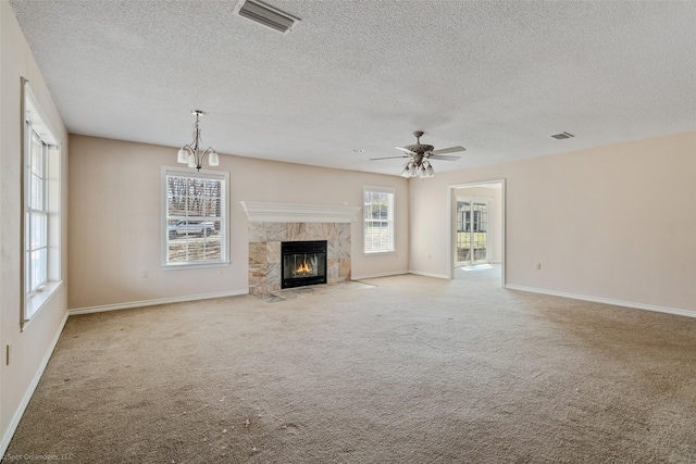 unfurnished living room featuring carpet floors, visible vents, and a high end fireplace