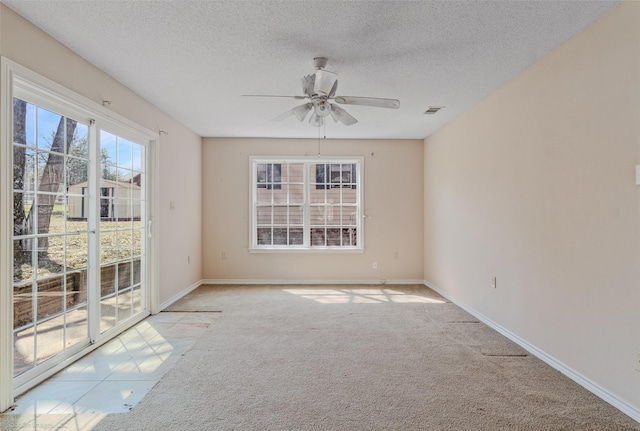 spare room with baseboards, visible vents, a ceiling fan, a textured ceiling, and carpet floors