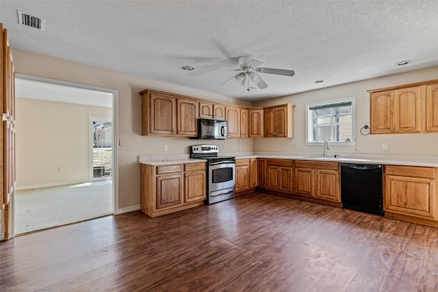 kitchen featuring black appliances, dark wood-type flooring, a sink, and visible vents