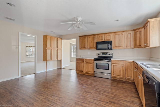 kitchen featuring black appliances, a wealth of natural light, dark wood-style flooring, and visible vents