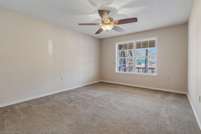 empty room featuring ceiling fan, baseboards, a textured ceiling, and carpet flooring