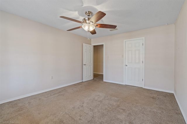 unfurnished bedroom with a ceiling fan, carpet flooring, a textured ceiling, and baseboards