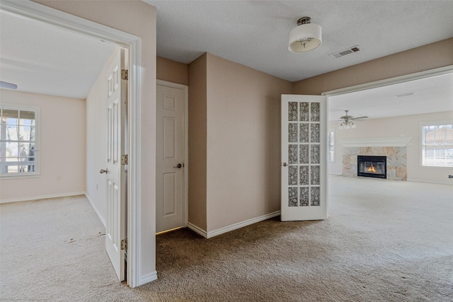 hall featuring carpet floors, visible vents, and baseboards