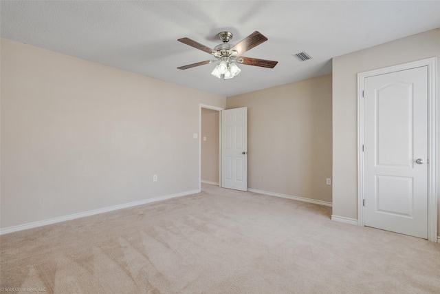 unfurnished bedroom featuring visible vents, ceiling fan, light carpet, and baseboards