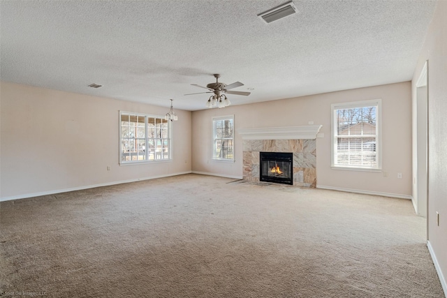 unfurnished living room featuring carpet floors, visible vents, and a healthy amount of sunlight