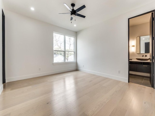 unfurnished bedroom featuring light wood-style flooring, baseboards, connected bathroom, and recessed lighting