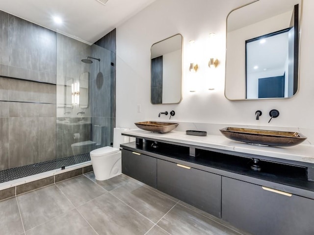 full bathroom featuring double vanity, a sink, toilet, and a walk in shower