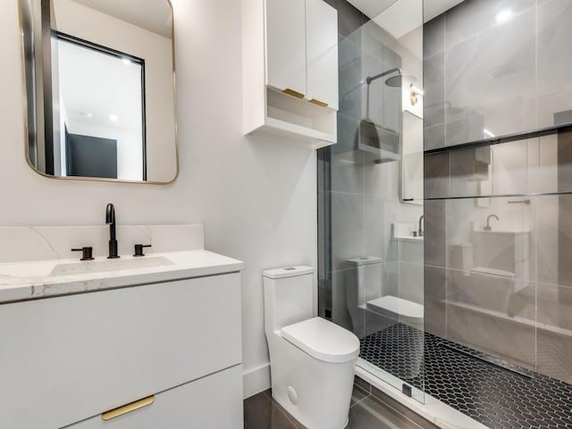 bathroom featuring a shower stall, toilet, and vanity