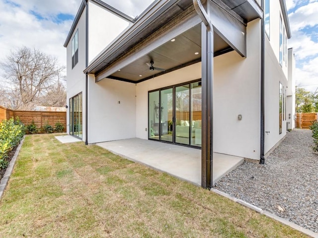 rear view of house featuring a patio, a lawn, a fenced backyard, and stucco siding