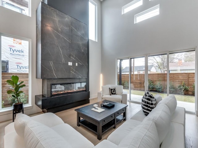 living room with a premium fireplace, plenty of natural light, and wood finished floors