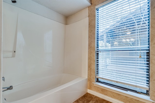 bathroom with tile patterned flooring, a textured ceiling, and shower / tub combination