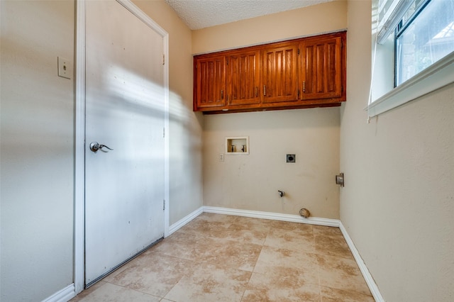 clothes washing area featuring cabinet space, baseboards, a textured ceiling, hookup for an electric dryer, and washer hookup