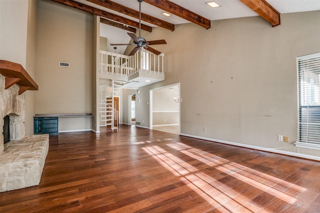 unfurnished living room with visible vents, a stone fireplace, baseboards, and hardwood / wood-style flooring