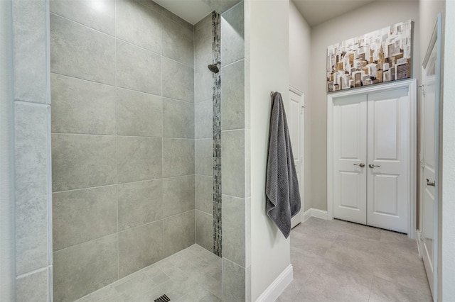 bathroom with baseboards and a tile shower