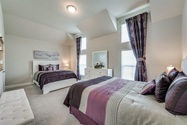 carpeted bedroom featuring vaulted ceiling and baseboards