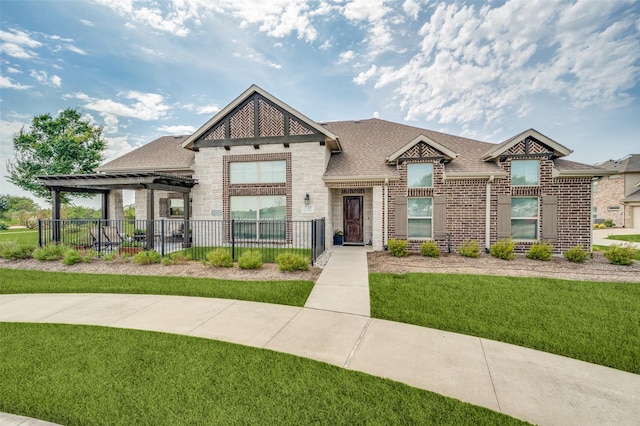 view of front of home with brick siding, a shingled roof, fence, a pergola, and a front lawn