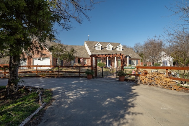 view of front of home with brick siding, a fenced front yard, a gate, and a pergola