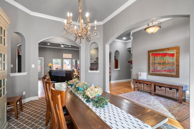 dining area with arched walkways, ornamental molding, hardwood / wood-style flooring, and baseboards