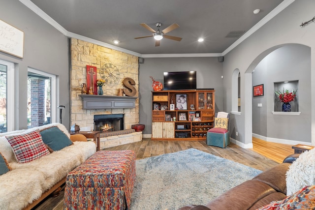 living room with visible vents, a fireplace, ornamental molding, and wood finished floors