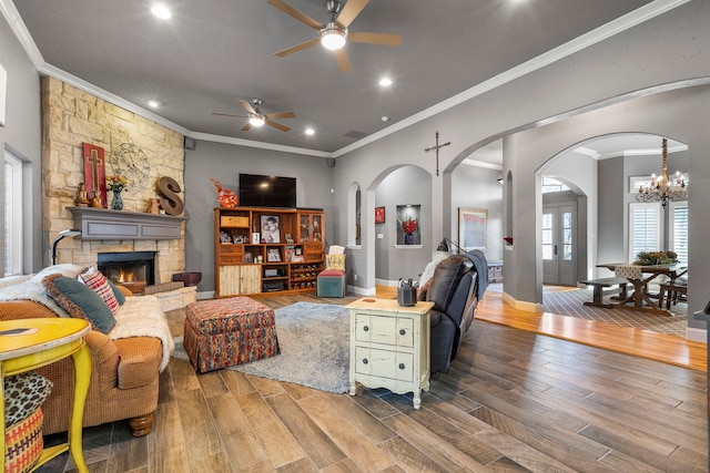 living room featuring baseboards, a stone fireplace, wood finished floors, and crown molding